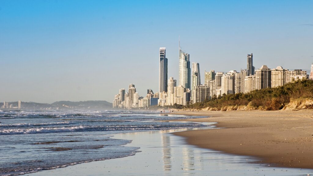 Stunning view of skyscrapers lining the golden beach under clear skies.
