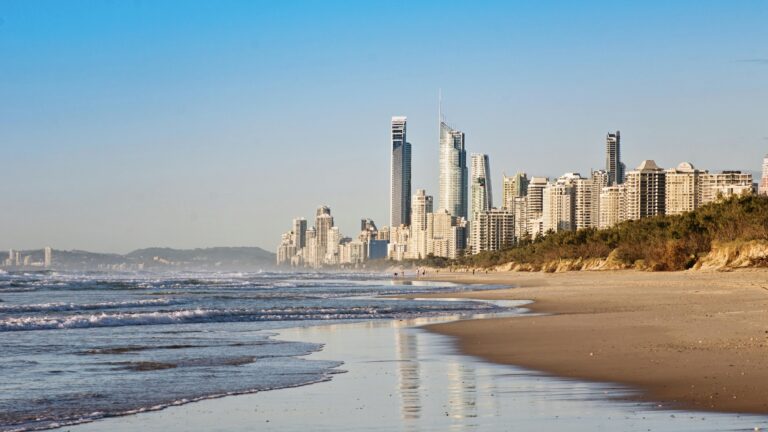 Stunning view of skyscrapers lining the golden beach under clear skies.